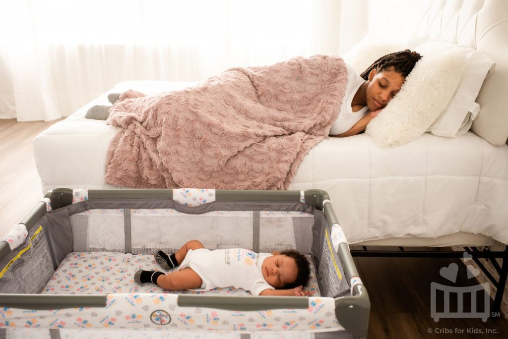 Baby sleeping in crib in mother's room